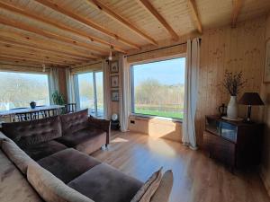 un soggiorno con divano e una grande finestra di Modern family house by the lake in Zarasai a Štadviliai