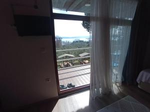 um quarto com uma janela com vista para uma varanda em ılıca anatolia pansiyon em Boyalıca