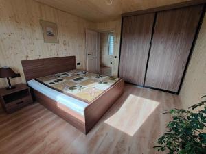 1 dormitorio con 1 cama y suelo de madera en Modern family house by the lake in Zarasai, en Štadviliai