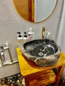 a bathroom sink on a wooden table with a mirror at AKa HOMESTAY in Yên Minh