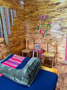 a bedroom with a bed and two chairs and a table at AKa HOMESTAY in Yên Minh