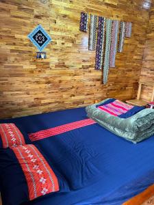 a bed in a room with a wooden wall at AKa HOMESTAY in Yên Minh