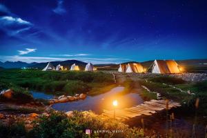 Mantri Bai Camping Site Deosai في سكردو: مجموعة من الخيام في حقل ليلا