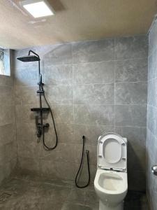 a bathroom with a toilet and a shower at Seladah Stay in Kuching