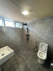 a bathroom with a toilet and a sink at Seladah Stay in Kuching
