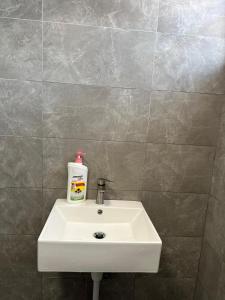 a bathroom sink with a bottle of soap on it at Seladah Stay in Kuching