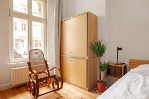 ベルリンにあるTolles Apartment im Helmholz-Kiez Prenzlauer Bergのベッドルーム(椅子付)、大きなキャビネットが備わります。