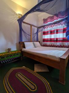 a bedroom with a canopy bed and a rug at Flamingo Guest House ZNZ in Stone Town