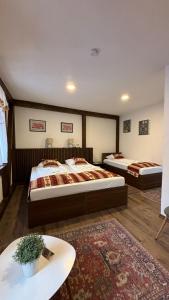 a hotel room with two beds and a table at Apartments HAN Alifakovac-Sarajevo in Sarajevo