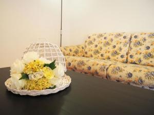 a basket of flowers on a table next to a couch at Ferienwohnung für 4 Personen ca 90 qm in Botricello, Kalabrien Provinz Catanzaro in Botricello