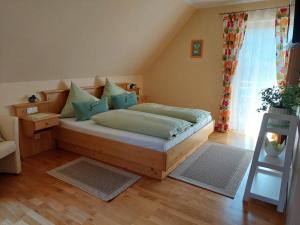 a bedroom with a bed with blue pillows at Ferienwohnung Stoff in Kitzeck im Sausal