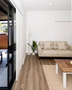 a living room with a couch and a table at Modern Home in the Heart of Bankstown in Bankstown