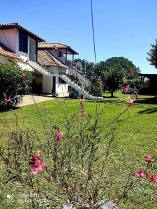 a house with pink flowers in front of a yard at Thea apartments 3 in Platamonas