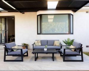 a patio with a couch and two chairs and a table at Modern Home in the Heart of Bankstown in Bankstown