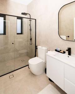 a bathroom with a shower and a toilet and a sink at Modern Home in the Heart of Bankstown in Bankstown