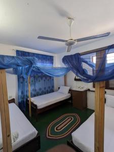 a bedroom with two bunk beds and a ceiling at Flamingo Guest House ZNZ in Stone Town