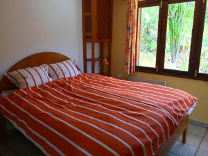 a bed with a red and white striped comforter in a bedroom at Casa Visioneros Tijarafe LaPalma in Casaquemada
