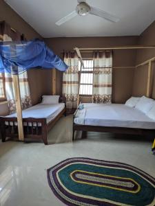 a bedroom with two bunk beds and a rug at Flamingo Guest House ZNZ in Stone Town