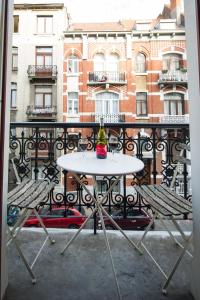 d'une table blanche et de deux chaises sur un balcon. dans l'établissement Grand appartement d'artiste cosy et proche de tout, à Bruxelles
