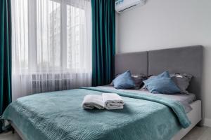um quarto com uma cama com toalhas em Атлантическая бриза em Almaty