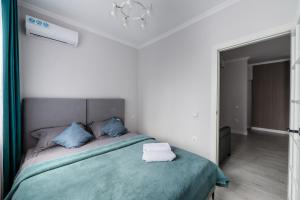 um quarto com uma cama com almofadas azuis em Атлантическая бриза em Almaty