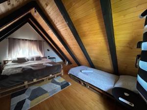 a attic bedroom with two beds and a couch at Jerry's Cottage Banja Luka in Banja Luka