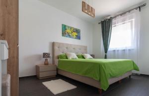 um quarto com uma cama verde e uma janela em Ferienwohnung für 4 Personen ca 55 qm in Privlaka, Dalmatien Norddalmatien em Privlaka