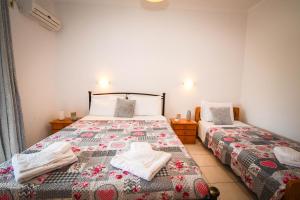 a bedroom with two beds with towels on them at Varvarigos Village in Zakynthos