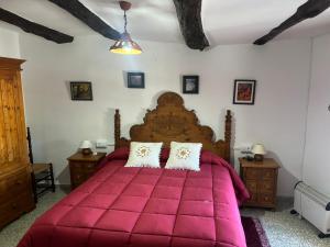 a bedroom with a large red bed with two pillows at Casa Pepo in Pampaneira