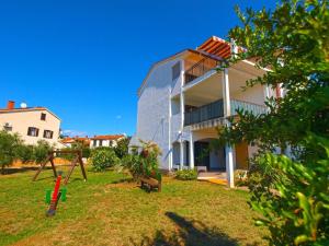 a house with a yard with a swing at Ferienwohnung für 4 Personen ca 45 qm in Fažana, Istrien Istrische Riviera in Fažana
