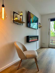 a living room with a chair and a tv at 2Br freeParking DUS Airp DUS Ess NTFLX in Wuppertal