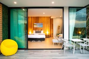 a hotel room with a bed and a table and chairs at Ao Luek Panoramic Pool-SHA Plus in Ao Luk