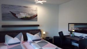 ein Schlafzimmer mit einem Bett, einem Schreibtisch und einem Gemälde in der Unterkunft Ferienwohnung für 5 Personen ca 52 m in Sankt Englmar, Bayern Bayerischer Wald in Sankt Englmar