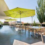 a patio area with tables and umbrellas at Hotel Granollers in Granollers