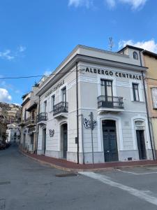 un gran edificio blanco en la esquina de una calle en B&B Albergo Centrale Gioiosa Ionica, en Gioiosa Ionica