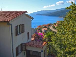 een uitzicht op een huis met uitzicht op het water bij Ferienwohnung für 3 Personen ca 35 qm in Rabac, Istrien Bucht von Rabac in Rabac