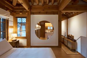 a bedroom with a bed and a round mirror at Luxury hanok with private bathtub - SN01 in Seoul