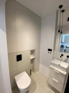 biała łazienka z toaletą i umywalką w obiekcie BlueHouse Apartment Warsaw w Warszawie