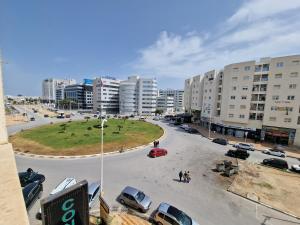 una strada cittadina con auto parcheggiate in un parcheggio di Tom II Expresse Médical a Tunisi