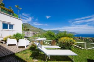 una terraza con sillas blancas y vistas al océano. en Ferienwohnung für 4 Personen ca 45 qm in Taormina, Sizilien Ostküste von Sizilien - b57254, en Taormina