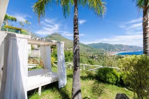 una cama en el lateral de una casa con palmeras en Ferienwohnung für 4 Personen ca 45 qm in Taormina, Sizilien Ostküste von Sizilien - b57254, en Taormina