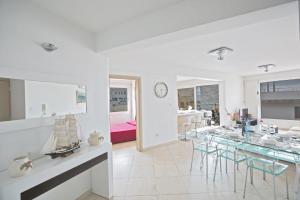 a white dining room with a glass table and chairs at Ferienwohnung für 7 Personen ca 90 qm in Protaras, Südküste von Zypern in Protaras