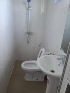 Baño blanco con aseo y lavamanos en SULTANA APPARTMENTS, en Mwanza