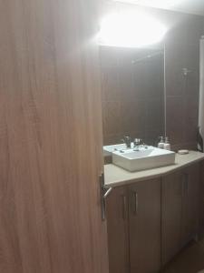 ein Badezimmer mit einem weißen Waschbecken und einem Spiegel in der Unterkunft Maria's Paradise in Vónitsa