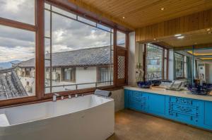 eine große Küche mit einer großen Badewanne und großen Fenstern in der Unterkunft Dream Tour Scenic Inn 梦之旅观景客栈 in Lijiang