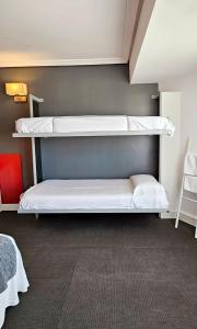 Hotel Spa El Muelle de Suances في سوانسيس: سريرين بطابقين في غرفة صغيرة مع