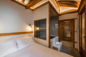 a bedroom with a white bed and a window at Luxury hanok with private bathtub - SN05 in Seoul