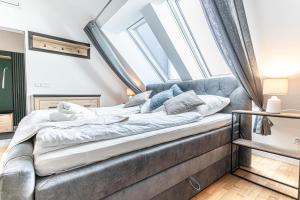 een bed in een kamer met dakramen bij 9 min to Center - Luxury Airconditioned w/ Balcony in Wenen