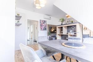 een eetkamer en een woonkamer met een tafel en stoelen bij 9 min to Center - Luxury Airconditioned w/ Balcony in Wenen