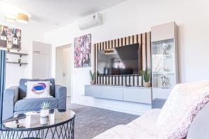 Una sala de estar con un sofá y un televisor. en Luxury 2BR and 1LR Apartment with Balcony - 9 min to Center, en Viena